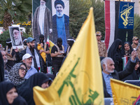 Islamic Revolutionary Guard Corps (IRGC) personnel, wearing masks and uniforms symbolizing Hamas warriors, stand under portraits of Iran's S...