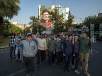 Young Iranian men shout anti-U.S. and anti-Israeli slogans while walking under a portrait of Lebanon's Hezbollah Secretary General, Hashem S...