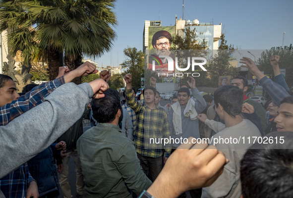 Young Iranian men shout anti-U.S. and anti-Israeli slogans under a portrait of Lebanon's Hezbollah Secretary General, Hashem Safieddine, who...