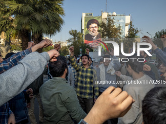 Young Iranian men shout anti-U.S. and anti-Israeli slogans under a portrait of Lebanon's Hezbollah Secretary General, Hashem Safieddine, who...