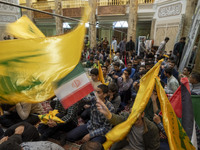 Iranian men wave an Iranian flag and flags of Lebanon's Hezbollah while taking part in a ceremony commemorating the killed Hamas Leader, Yah...