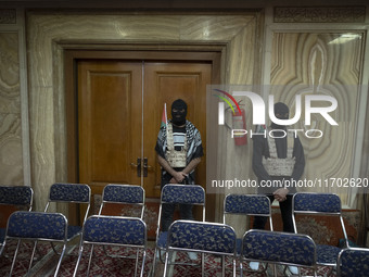 Islamic Revolutionary Guard Corps (IRGC) personnel wear masks and flak jackets, symbolizing Hamas warriors, and stand at attention during a...