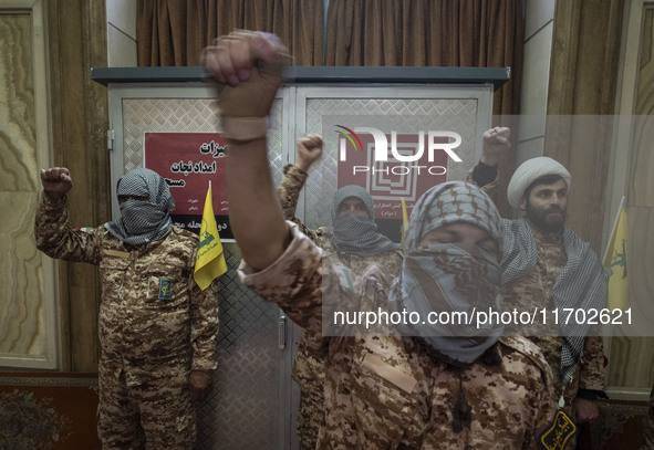 Islamic Revolutionary Guard Corps (IRGC) military personnel wear Palestinian scarves and uniforms, symbolizing Hamas warriors, and shout ant...