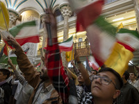 Iranian men wave an Iranian flag and flags of Lebanon's Hezbollah while taking part in a ceremony commemorating the killed Hamas Leader, Yah...