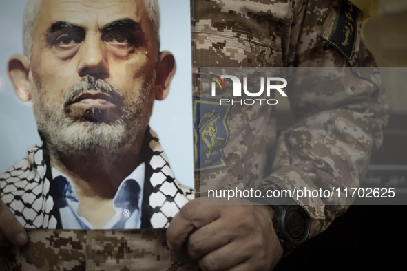 An Islamic Revolutionary Guard Corps (IRGC) military personnel holds a portrait of the killed Hamas Leader, Yahya Sinwar, while taking part...