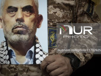 An Islamic Revolutionary Guard Corps (IRGC) military personnel holds a portrait of the killed Hamas Leader, Yahya Sinwar, while taking part...