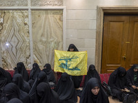 A veiled Iranian woman holds a flag of Lebanon's Hezbollah while participating in a ceremony commemorating the killed Hamas leader, Yahya Si...