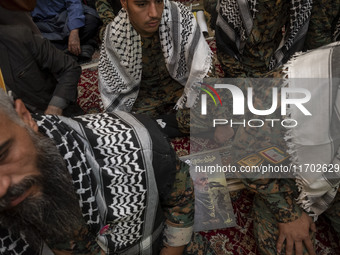 Islamic Revolutionary Guard Corps (IRGC) military personnel sit next to a portrait of the killed Hamas Leader, Yahya Sinwar, while taking pa...