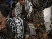 Islamic Revolutionary Guard Corps (IRGC) military personnel sit next to a portrait of the killed Hamas Leader, Yahya Sinwar, while taking pa...