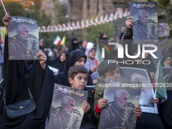 Iranian schoolboys and veiled women hold portraits of the killed Hamas Leader, Yahya Sinwar, while they take part in a ceremony commemoratin...