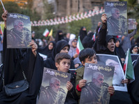 Iranian schoolboys and veiled women hold portraits of the killed Hamas Leader, Yahya Sinwar, while they take part in a ceremony commemoratin...