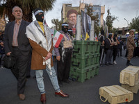 A group of Iranian men, wearing masks and flak jackets, symbolizes Hamas warriors and stands next to two tank bullet pumices during a ceremo...