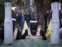 Two Islamic Revolutionary Guard Corps (IRGC) military personnel, wearing masks and flak jackets, symbolize Hamas warriors as they stand next...