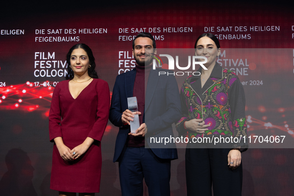 Amin Sadraei, Mahsa Rostami, and Setareh Maleki receive the Hollywood Reporter Award during the closing award ceremony of the Cologne Film F...