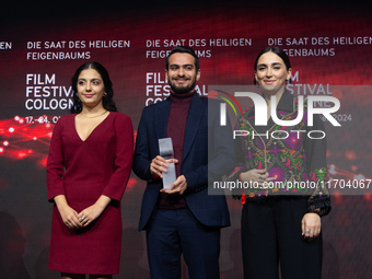 Amin Sadraei, Mahsa Rostami, and Setareh Maleki receive the Hollywood Reporter Award during the closing award ceremony of the Cologne Film F...