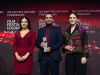 Amin Sadraei, Mahsa Rostami, and Setareh Maleki receive the Hollywood Reporter Award during the closing award ceremony of the Cologne Film F...