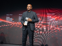 Raoul Peck, a Haitian filmmaker, receives the film prize award during the closing award ceremony of the Cologne Film Festival 2024 at E-Werk...