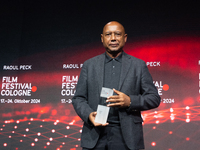 Raoul Peck, a Haitian filmmaker, receives the film prize award during the closing award ceremony of the Cologne Film Festival 2024 at E-Werk...