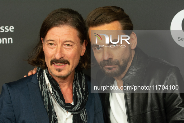 Dean BayKkan, a German actor, and Romano Brusa, a German actor, pose on the red carpet before the closing award ceremony of the Cologne Film...