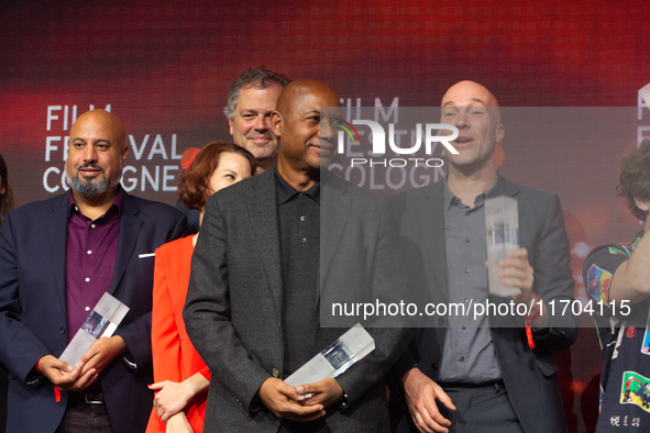 Raoul Peck, a Haitian filmmaker, and other prize winners take group pictures during the closing award ceremony of the Cologne Film Festival...