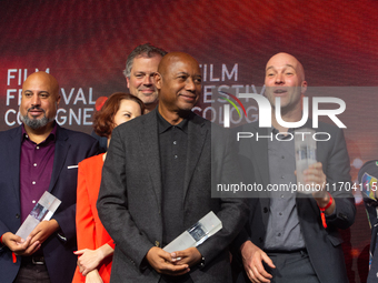 Raoul Peck, a Haitian filmmaker, and other prize winners take group pictures during the closing award ceremony of the Cologne Film Festival...