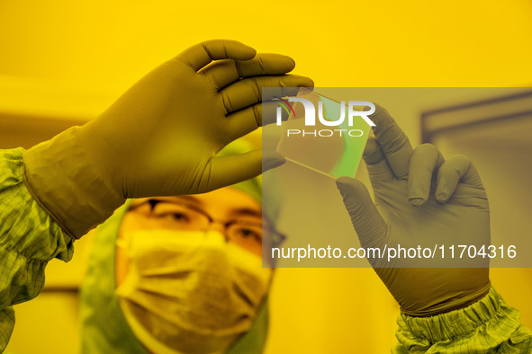 A researcher checks grating substrates in the yellow light detection room at the research building of Anhui Zhongke Grating Technology Co.,...