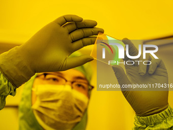 A researcher checks grating substrates in the yellow light detection room at the research building of Anhui Zhongke Grating Technology Co.,...