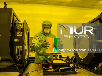 A researcher inspects grating surface patterns in the yellow light detection room of Anhui Zhongke Grating Technology Co., LTD in Hefei, Chi...