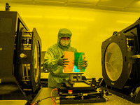 A researcher inspects grating surface patterns in the yellow light detection room of Anhui Zhongke Grating Technology Co., LTD in Hefei, Chi...