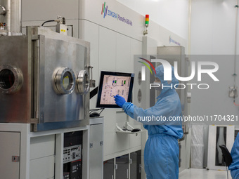 A researcher operates a grating ion beam etcher in the yellow light detection room at the research building of Anhui Zhongke Grating Technol...