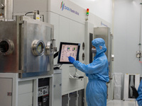 A researcher operates a grating ion beam etcher in the yellow light detection room at the research building of Anhui Zhongke Grating Technol...