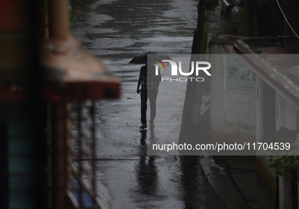 A man walks on the street during rain due to Cyclone Dana in Kolkata, India, on October 25, 2024. The coastal districts of Odisha are batter...