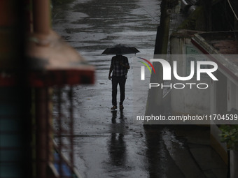 A man walks on the street during rain due to Cyclone Dana in Kolkata, India, on October 25, 2024. The coastal districts of Odisha are batter...