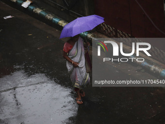 A woman walks on the street during rain due to Cyclone Dana in Kolkata, India, on October 25, 2024. The coastal districts of Odisha are batt...