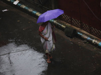 A woman walks on the street during rain due to Cyclone Dana in Kolkata, India, on October 25, 2024. The coastal districts of Odisha are batt...