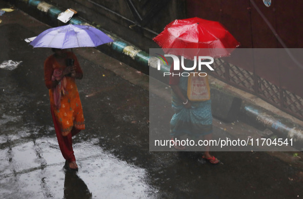 Women walk on the street during rain due to Cyclone Dana in Kolkata, India, on October 25, 2024. The coastal districts of Odisha are battere...