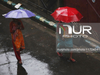 Women walk on the street during rain due to Cyclone Dana in Kolkata, India, on October 25, 2024. The coastal districts of Odisha are battere...