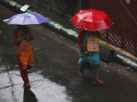 Women walk on the street during rain due to Cyclone Dana in Kolkata, India, on October 25, 2024. The coastal districts of Odisha are battere...