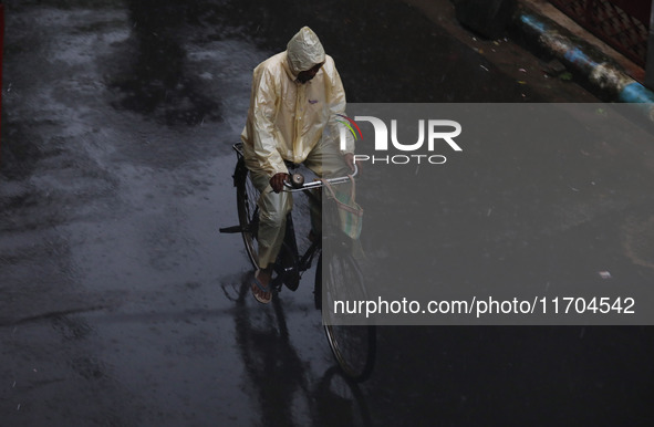 A man rides a bicycle on the street during rain due to Cyclone Dana in Kolkata, India, on October 25, 2024. The coastal districts of Odisha...