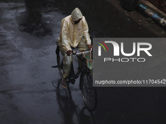 A man rides a bicycle on the street during rain due to Cyclone Dana in Kolkata, India, on October 25, 2024. The coastal districts of Odisha...