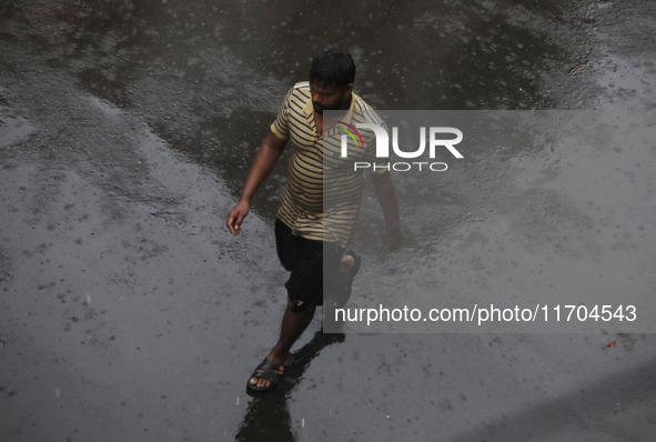 A man walks on the street during rain due to Cyclone Dana in Kolkata, India, on October 25, 2024. The coastal districts of Odisha are batter...