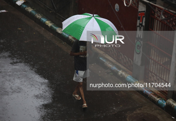 A woman walks on the street during rain due to Cyclone Dana in Kolkata, India, on October 25, 2024. The coastal districts of Odisha are batt...