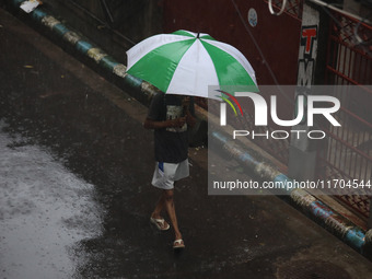 A woman walks on the street during rain due to Cyclone Dana in Kolkata, India, on October 25, 2024. The coastal districts of Odisha are batt...