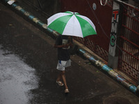 A woman walks on the street during rain due to Cyclone Dana in Kolkata, India, on October 25, 2024. The coastal districts of Odisha are batt...