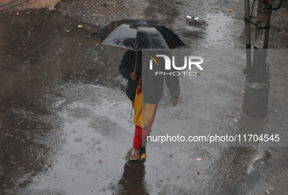 A woman walks on the street during rain due to Cyclone Dana in Kolkata, India, on October 25, 2024. The coastal districts of Odisha are batt...