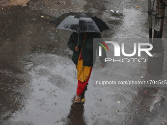 A woman walks on the street during rain due to Cyclone Dana in Kolkata, India, on October 25, 2024. The coastal districts of Odisha are batt...