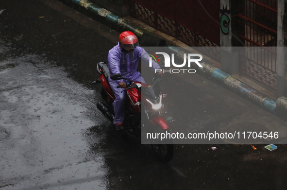 A man rides a motorcycle on the street during rain due to Cyclone Dana in Kolkata, India, on October 25, 2024. The coastal districts of Odis...