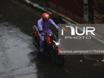 A man rides a motorcycle on the street during rain due to Cyclone Dana in Kolkata, India, on October 25, 2024. The coastal districts of Odis...