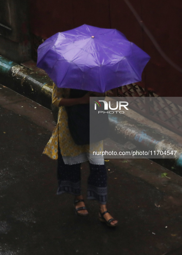 A woman walks on the street during rain due to Cyclone Dana in Kolkata, India, on October 25, 2024. The coastal districts of Odisha are batt...