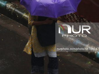 A woman walks on the street during rain due to Cyclone Dana in Kolkata, India, on October 25, 2024. The coastal districts of Odisha are batt...